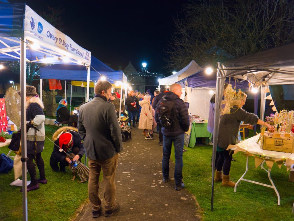 Gazebos in use at a busy outdoor community event in Ottery St Mary.