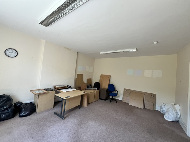 Wide view of a large office containing stored office furniture.