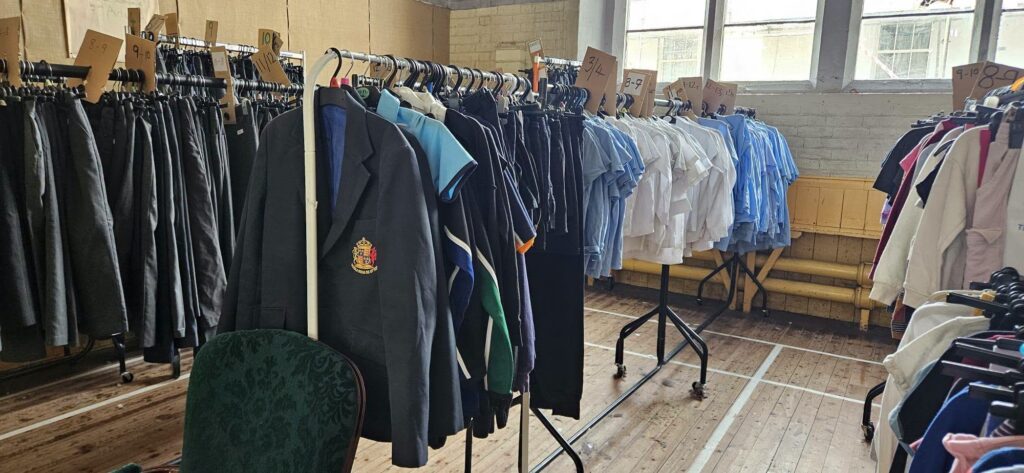Rails of school uniform clothing organised by size.