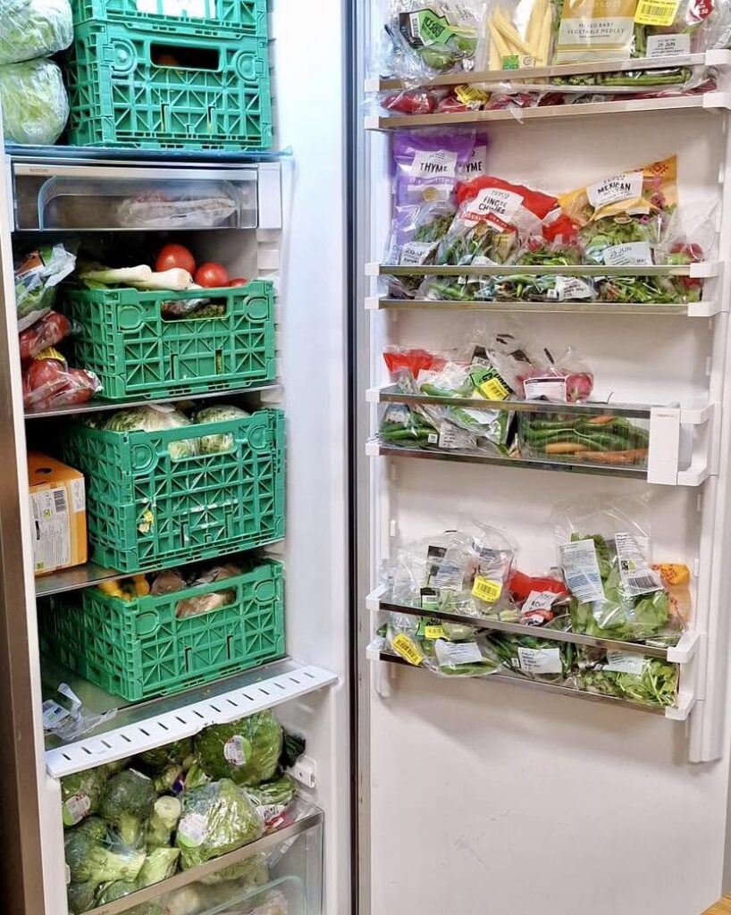 Open refrigerator stocked with fresh fruit and vegetables.