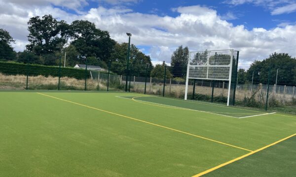 Outdoor sports court with artificial turf, court markings and sports goals.